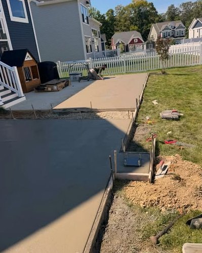 Gray concrete patio slabs beside a home with a white picket fence in Huntersville, NC
