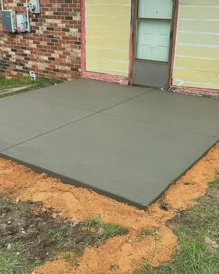 Gray concrete patio beside a brick and yellow siding home in Huntersville, NC