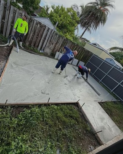 Crew screeding a concrete patio inside wood forms in a backyard in Huntersville, NC
