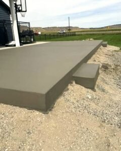 Raised gray concrete slab with a step beside a basketball hoop in Huntersville, NC