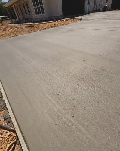 Large wide gray concrete pad beside new homes under construction in Huntersville, NC