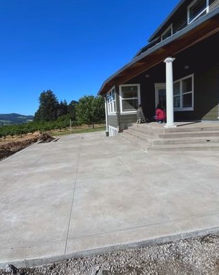 Large gray concrete patio slab beside steps at a dark two story home in Huntersville, NC